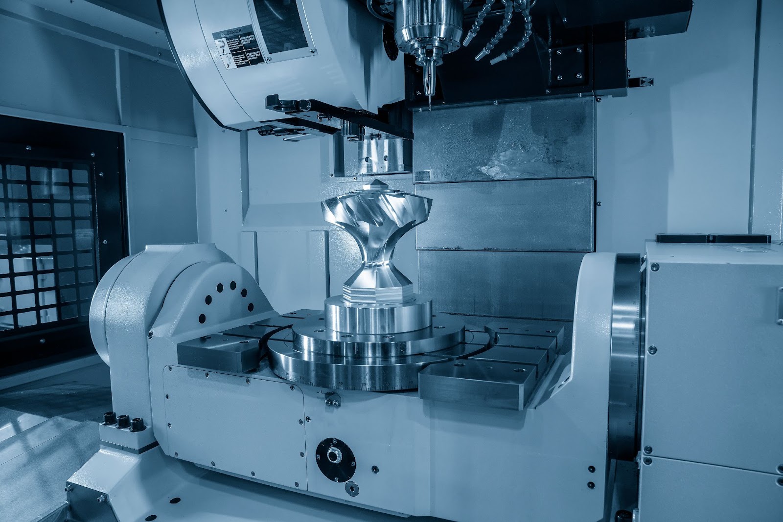Five-axis machining center cutting a precision graphite component